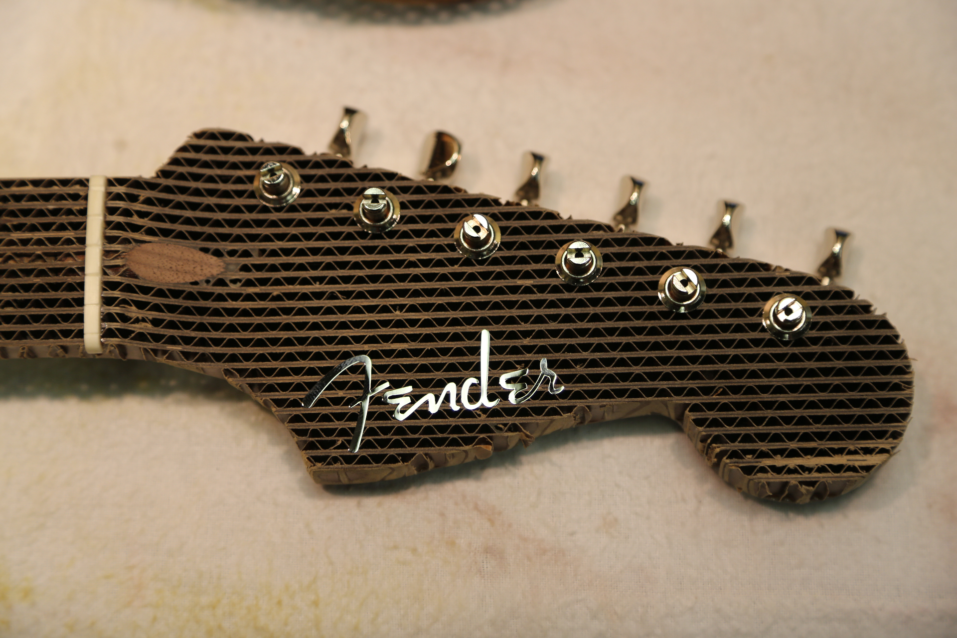 Close-up of the cardboard Stratocaster headstock with Fender script logo