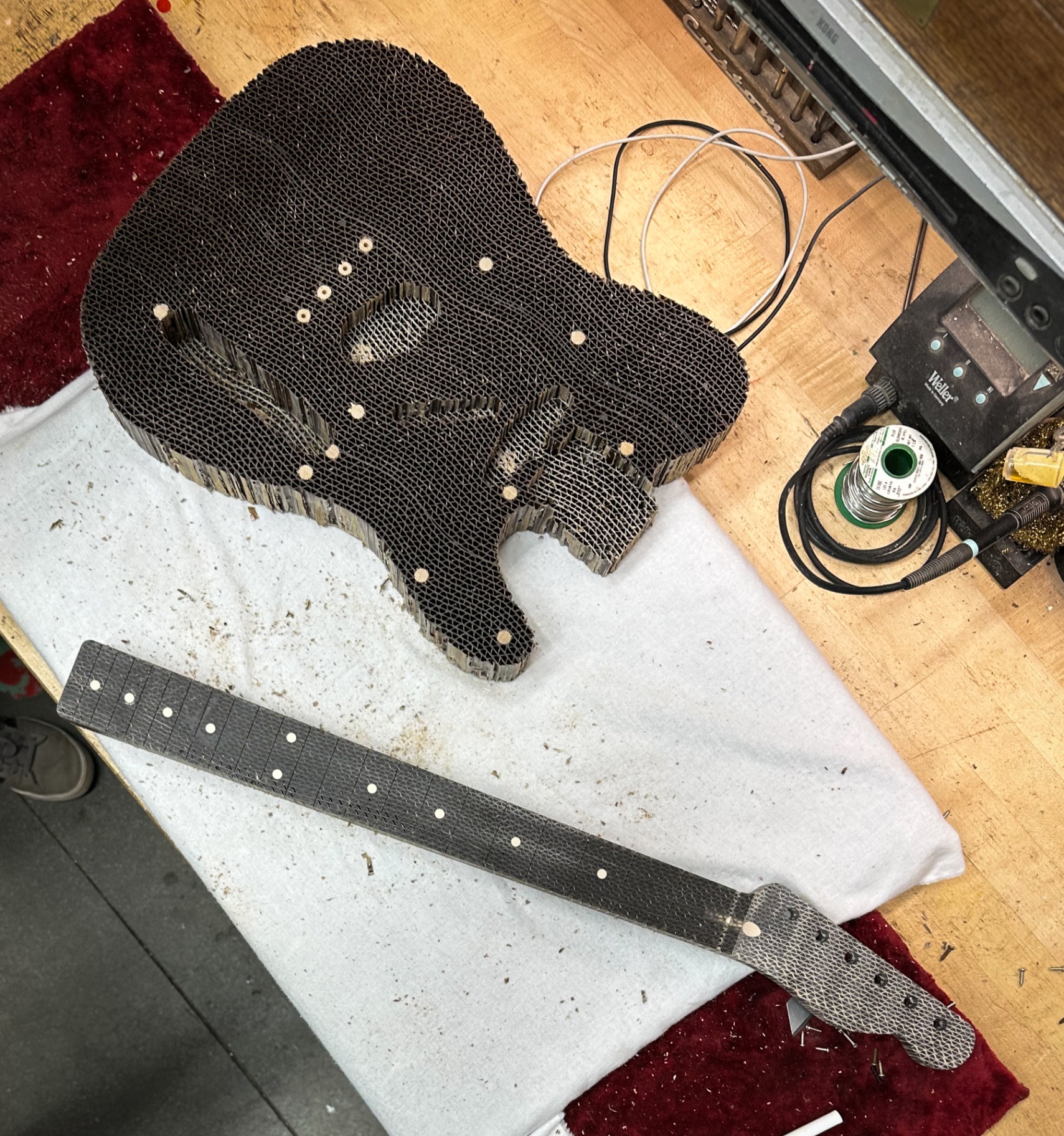 Overhead view of the corrugated Telecaster body and neck laid out on the workbench