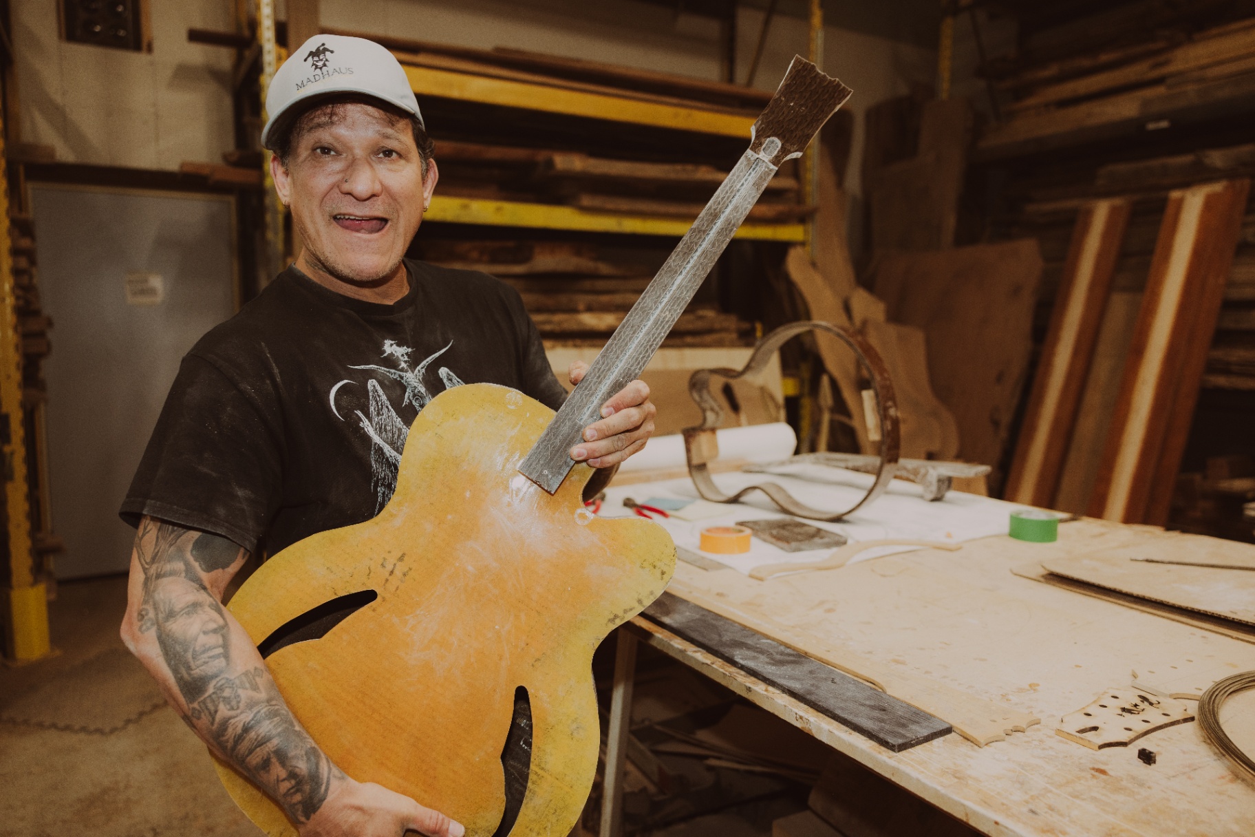 Gabriel holding up the raw glued cardboard body with the neck attached